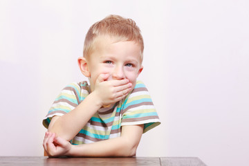 Portrait of happy laughing blond boy child kid at the table