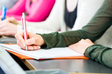 Studenten im Uni Hörsaal schreiben Klausur