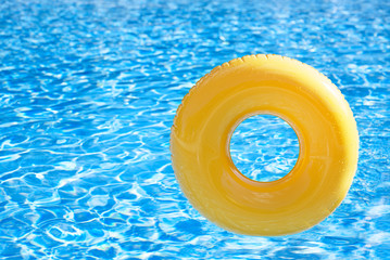 Fototapeta na wymiar pływający pierścień na niebieskim wody Swimpool odbijających fale