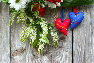 Dwa serca i kwiaty na drewnianym tle - obrazy, fototapety, plakaty