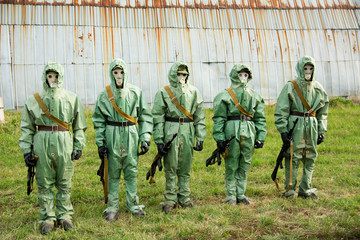 A group of soldiers with guns in their masks and protective clot