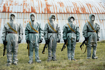 A group of soldiers with guns in their masks and protective clot