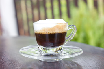 Hot  espresso with milk and foam in cup.