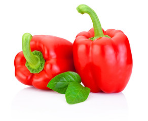 Two Sweet Red Peppers with green leaves isolated on white backgr