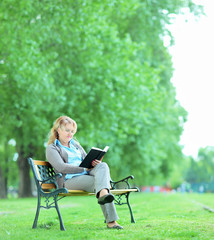 Mature woman reading a book in park