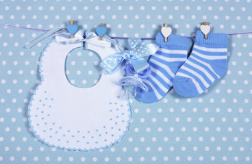 Baby boy socks and bib hanging from pegs on a line