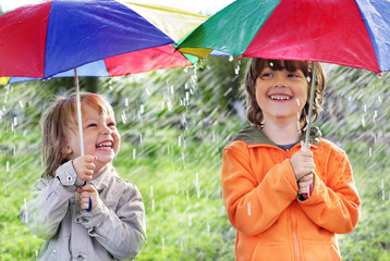 two happy brother with umbrella outdoors
