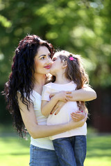 Happy mom and daughter. Walk in the green park