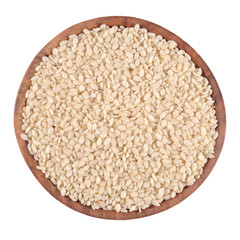 Sesame seeds in a wooden bowl on a white