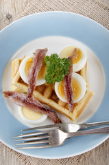 waffle with cooked egg and anchovis