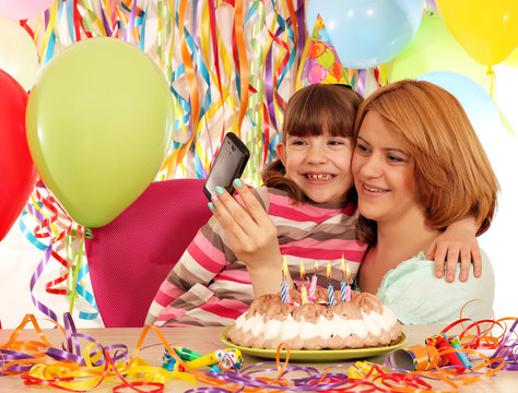 Mom and daughter take pictures at a birthday party