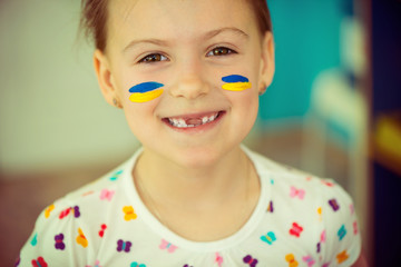 Ukrainian girl with national flag on cheek
