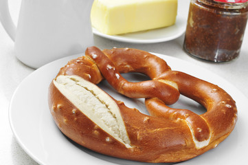 a laugenbrezel, a german pretzel, on a set table for breakfast