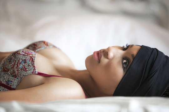Model lying on a bed and wearing a bra