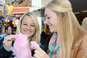 Frauen essen Zuckerwatter auf Kirmes