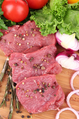Raw beef meat with vegetables on table close up