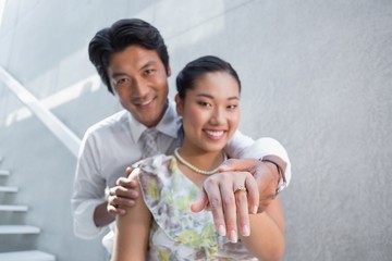 Couple showing engagement ring on womans finger
