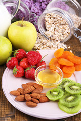 Healthy cereal with milk and fruits on wooden table