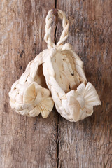 Kids braided bast shoes are hanging on a wooden door
