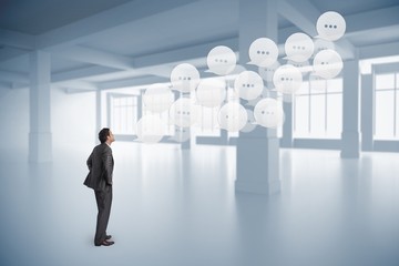 Obraz premium Composite image of serious businessman with hands on hips