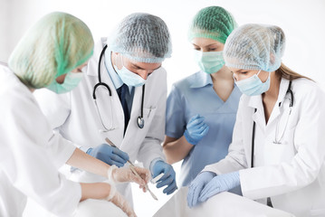 young group of doctors doing operation