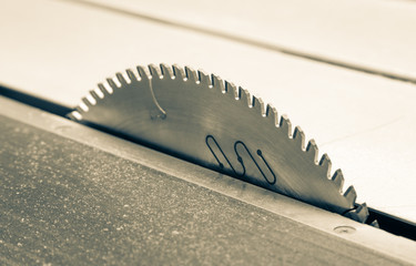 Circular saw blade on woodworking table, close up of industrial tool for carpentry, construction and workshop safety concept