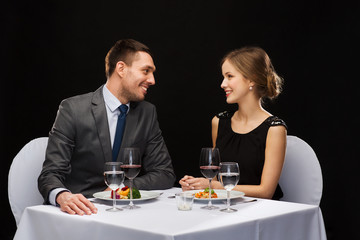 smiling couple eating main course at restaurant