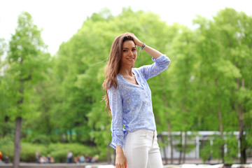 Happy young woman in white pants and blue shirt