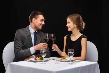 smiling couple eating main course at restaurant