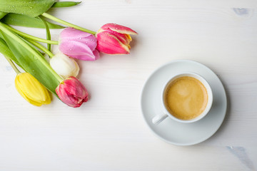 Fototapeta na wymiar Coffee and tulips on a white wood table with some water on the t