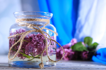 Beautiful lilac flowers in glass jar,