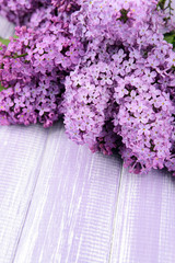 Beautiful lilac flowers on wooden background