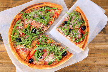 Pizza with arugula on color wooden background