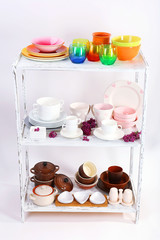 Different tableware on shelf, isolated on white