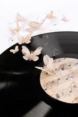 Old vinyl record with paper butterflies, isolated on white