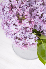 bouquet of lilac flowers on white wooden background