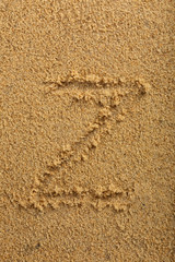 Alphabet letter written on wet beach sand