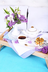 Light breakfast and beautiful bouquet on bed