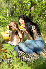 Obraz premium Happy mom and daughter. Picnic in the green park