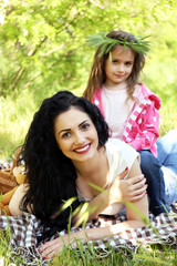Fototapeta premium Happy mom and daughter. Picnic in the green park
