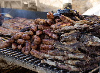 Fresh sausage and hot dogs grilling outdoors
