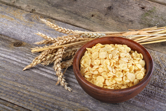 cornflakes in a wooden bowl with wheat