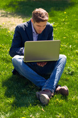 young business man on the grass. fashion style. talking skype. o