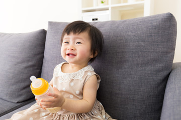 Asia baby girl holding milk bottle