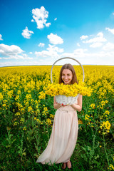 Beautiful happy girl having fun on the colza field.