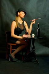 Kobieta przy stoliku z papierosem i lampką wina.