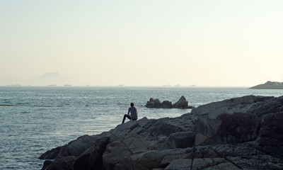 man sitting on the coast