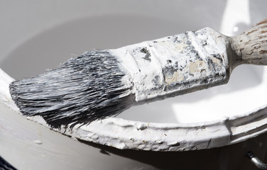 Professionals paint brush on the edge of a painters kettle