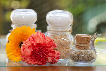 Obraz na płótnie Canvas Seasoned salt in jars with flowers