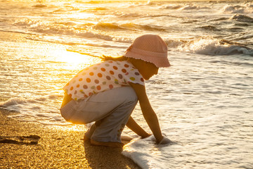 Happy active child splashing and playing in sea.